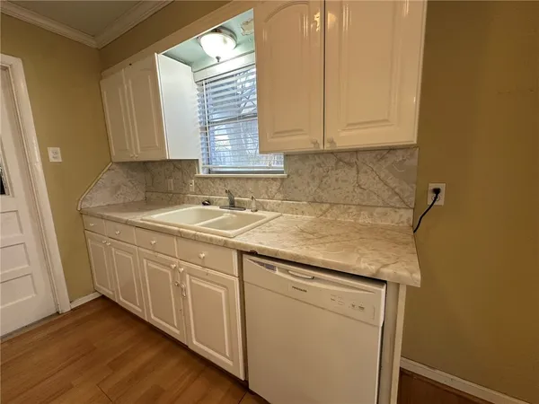 a kitchen with granite countertop white cabinets and sink