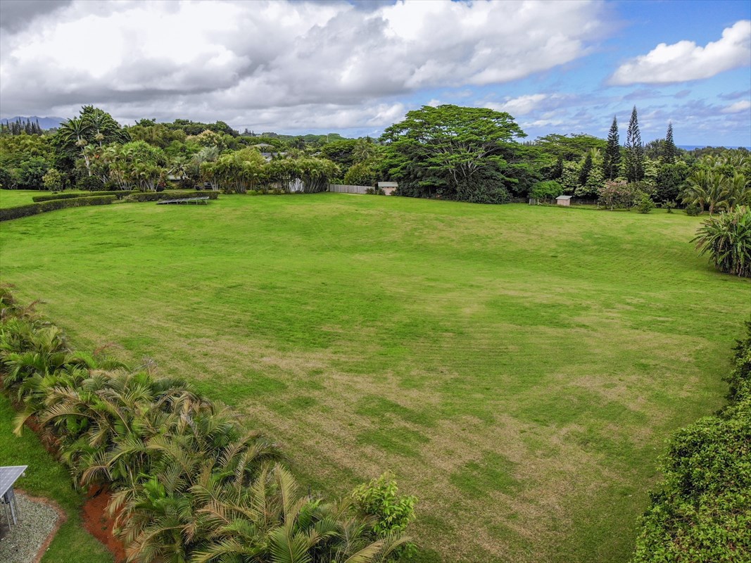 4327 Kapuna Road, Unit 2 Kilauea, HI 96754 - Photo 15 of 30 a view of a green yard with a building in the background