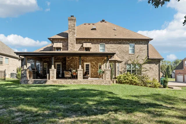 a view of a patio with table and chairs next to a yard with a patio