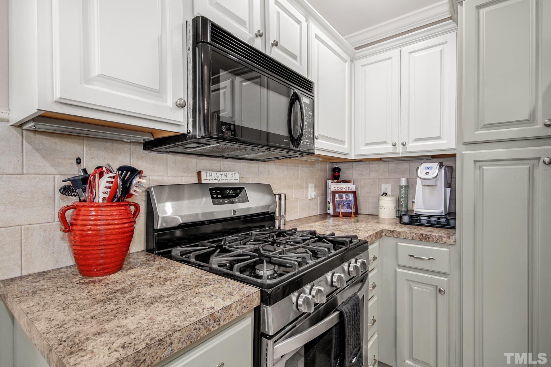 103 Lemon Drop Circle Apex, NC 27502 - Photo 11 of 20 a kitchen with stainless steel appliances granite countertop a stove a sink and cabinets