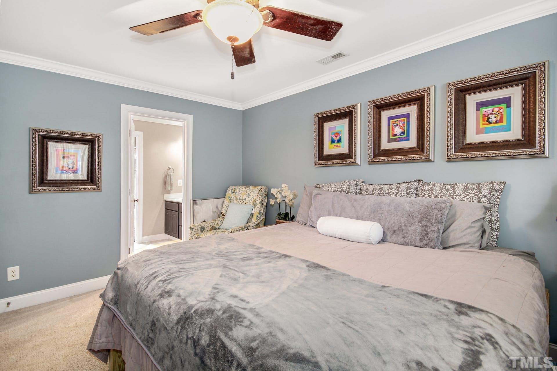 103 Lemon Drop Circle Apex, NC 27502 - Photo 13 of 20 a bedroom with a large bed and a ceiling fan