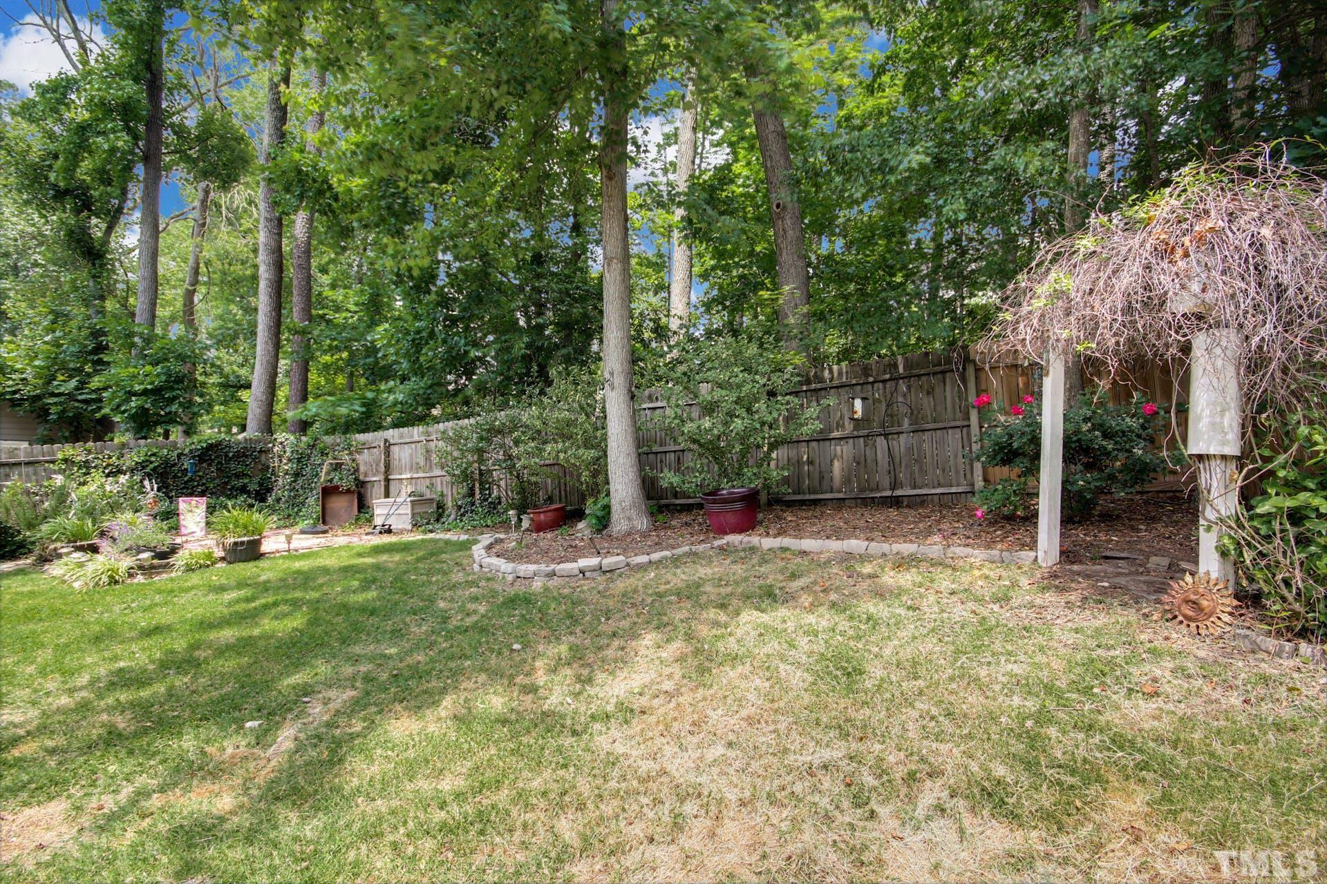 103 Lemon Drop Circle Apex, NC 27502 - Photo 20 of 20 a view of a backyard with table and chairs and potted plants and large trees