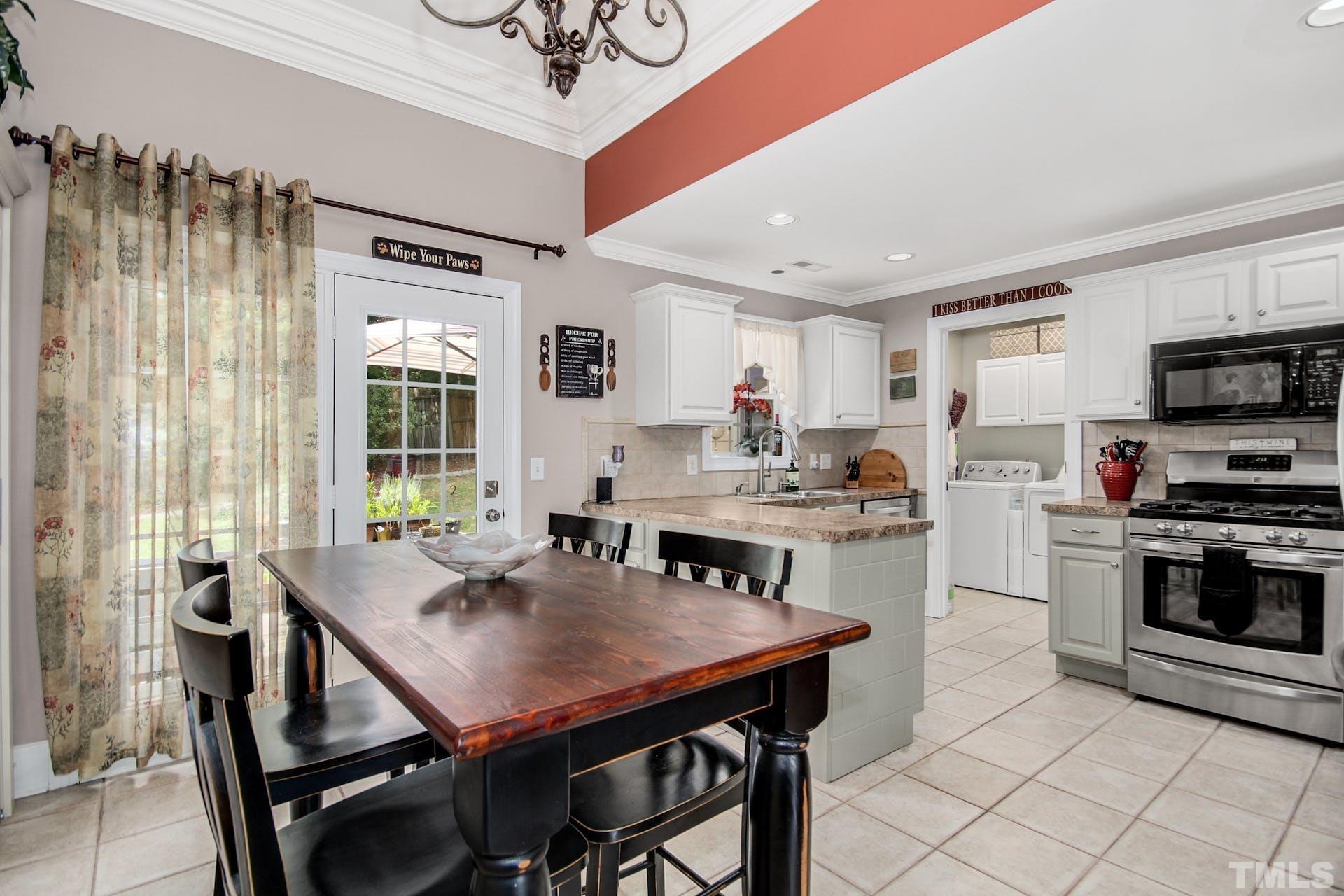 103 Lemon Drop Circle Apex, NC 27502 - Photo 8 of 20 a open dining room with stainless steel appliances a table and chairs