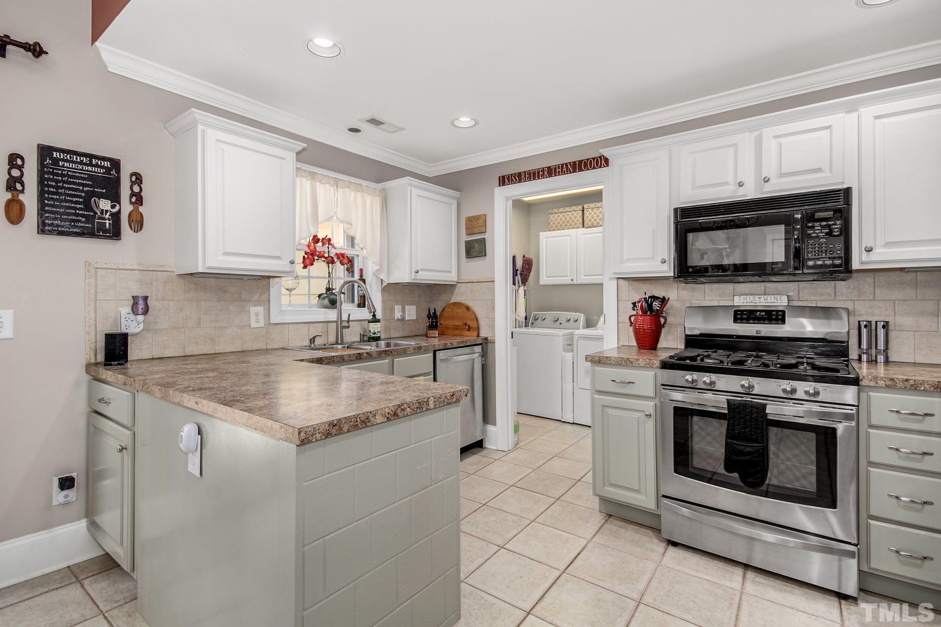 103 Lemon Drop Circle Apex, NC 27502 - Photo 9 of 20 a kitchen with stainless steel appliances granite countertop a sink dishwasher stove top oven and cabinets