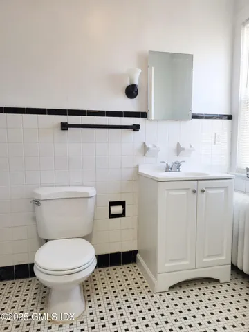 a bathroom with a sink a toilet and a mirror