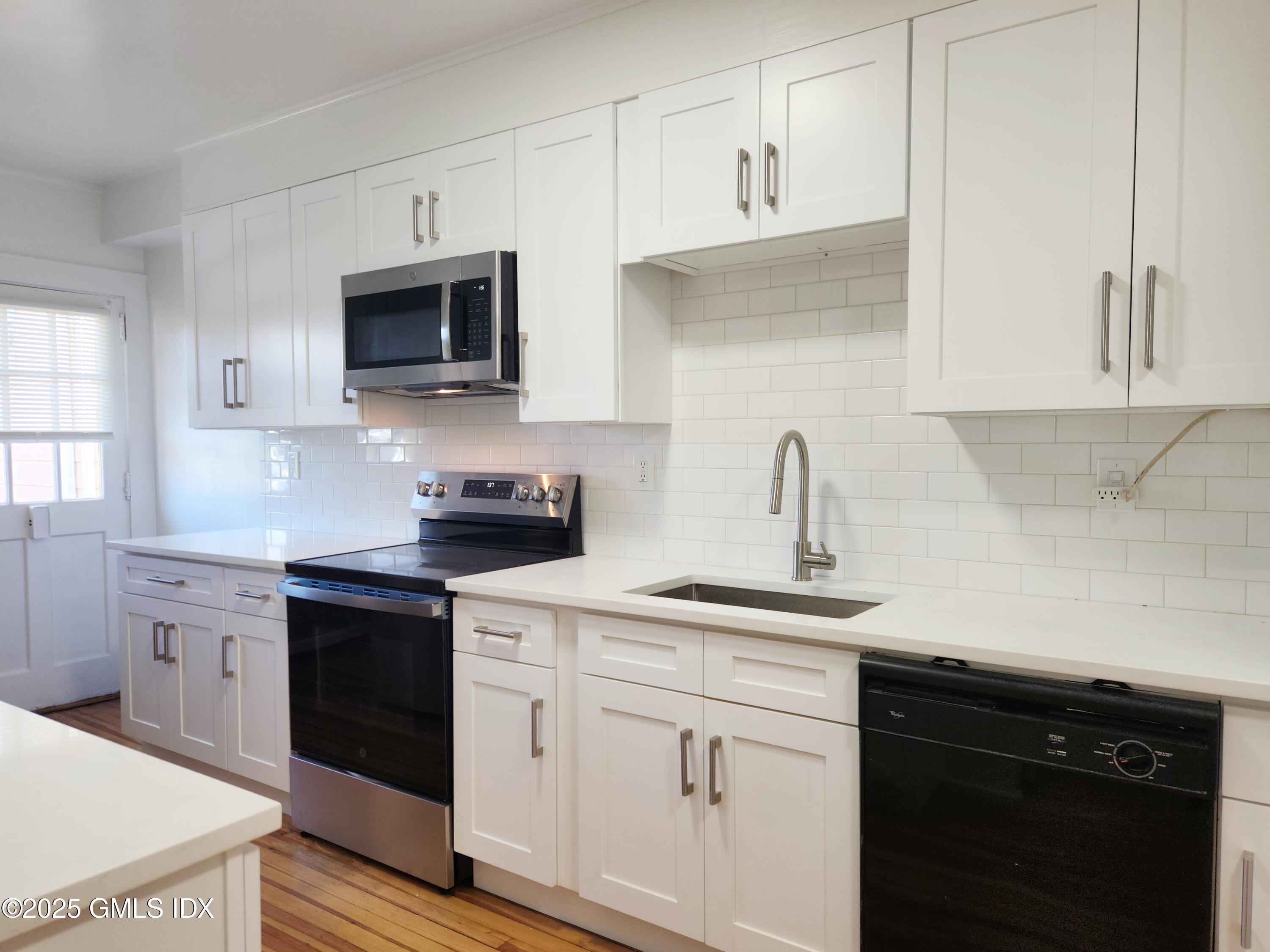 15 Scofield Street, Unit 1F Cos Cob, CT 06807 - Photo 2 of 15 a kitchen with white cabinets and sink