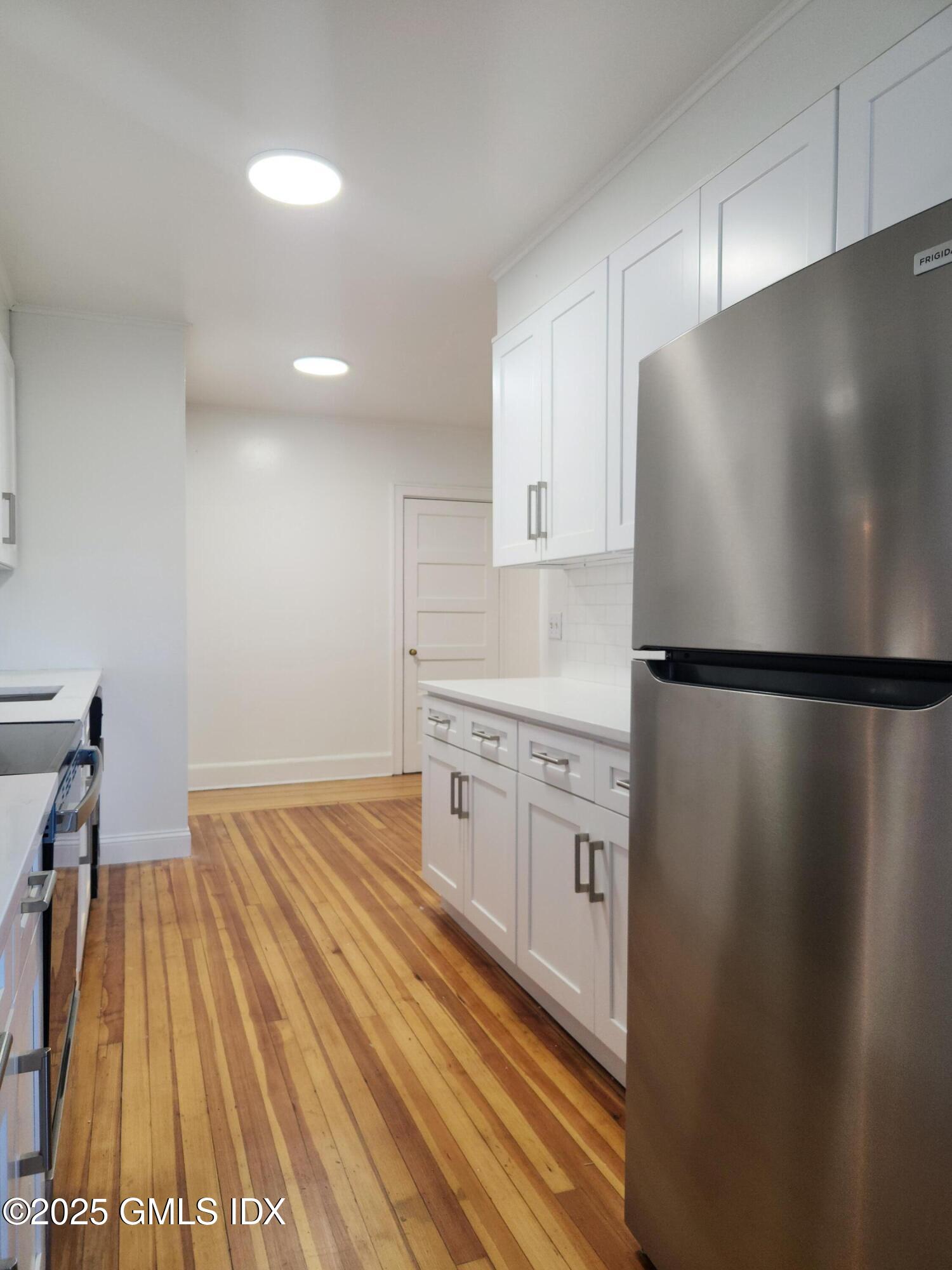 15 Scofield Street, Unit 1F Cos Cob, CT 06807 - Photo 4 of 15 a kitchen with white cabinets and stainless steel appliances