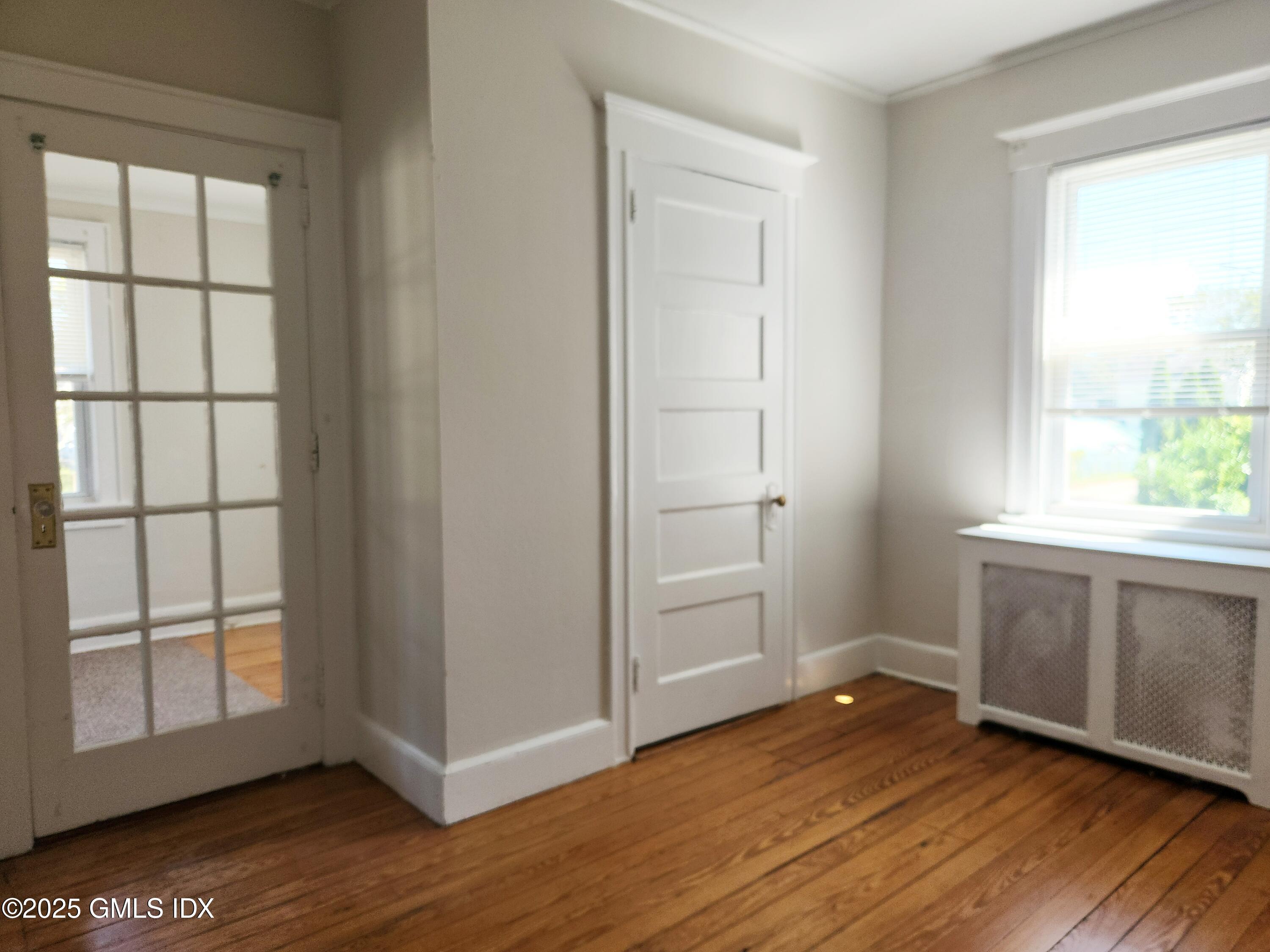 15 Scofield Street, Unit 1F Cos Cob, CT 06807 - Photo 9 of 15 an empty room with wooden floor and windows