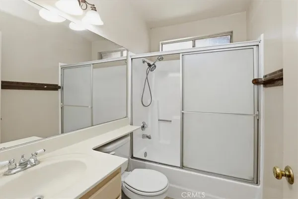 a white toilet sitting next to a white sink and a shower curtain