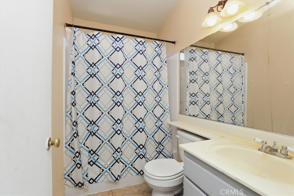 1907 Overland Street Colton, CA 92324 - Photo 20 of 36 a white toilet sitting next to a white sink and a shower curtain