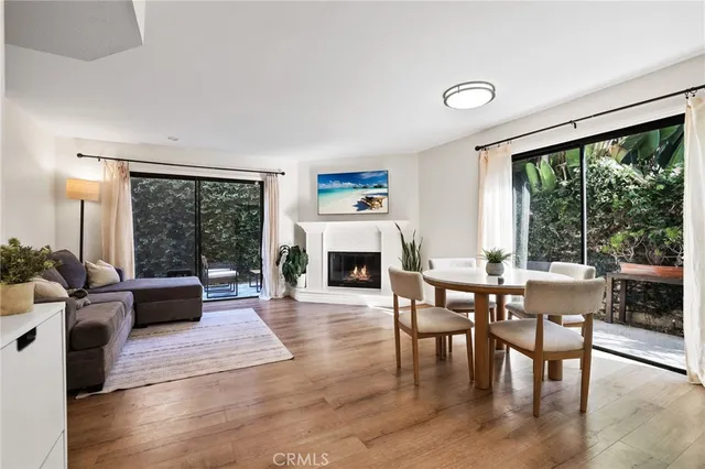 a living room with furniture large window and wooden floor