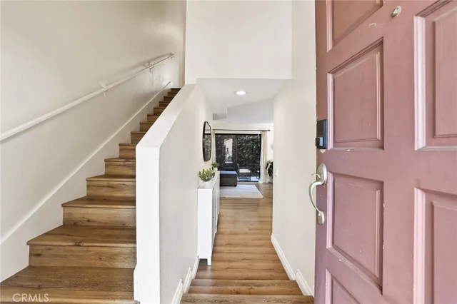 a view of a hallway with wooden floor and staircase