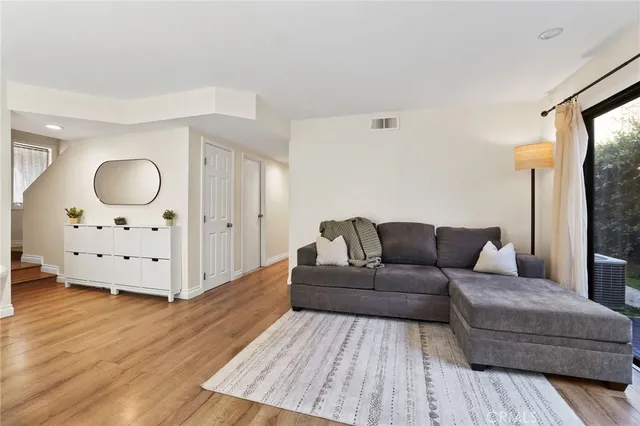 a living room with furniture and wooden floor