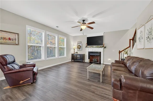 a living room with furniture a fireplace a flat screen tv and wooden floor