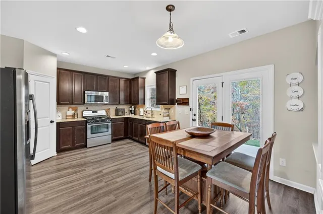 a kitchen with a table chairs stainless steel appliances and cabinets