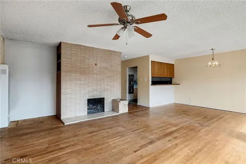 a living room with wooden floor and a fireplace