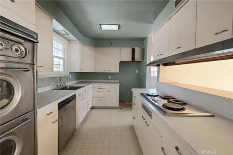 a kitchen with stainless steel appliances granite countertop a sink stove top oven and cabinets