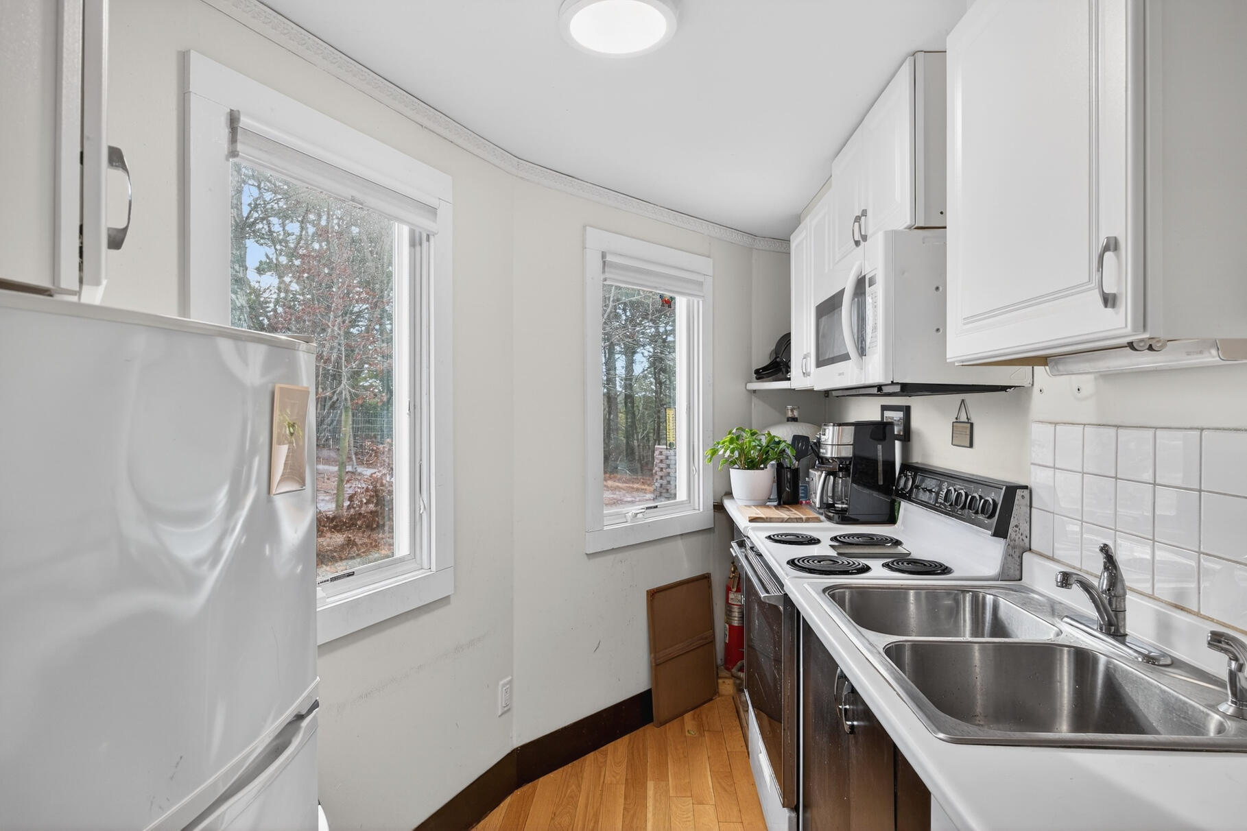 19 Old Bridge Road Truro, MA 02666 - Photo 11 of 27 a kitchen with stainless steel appliances a sink a stove and a refrigerator with wooden floor