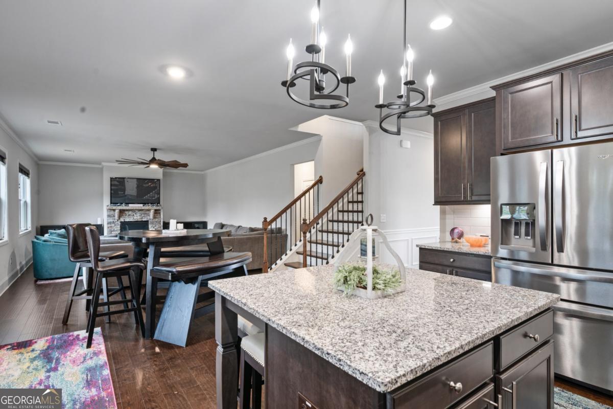 6780 Rambling Vale Dawsonville, GA 30534 - Photo 14 of 52 a kitchen with stainless steel appliances kitchen island granite countertop a table chairs and stove