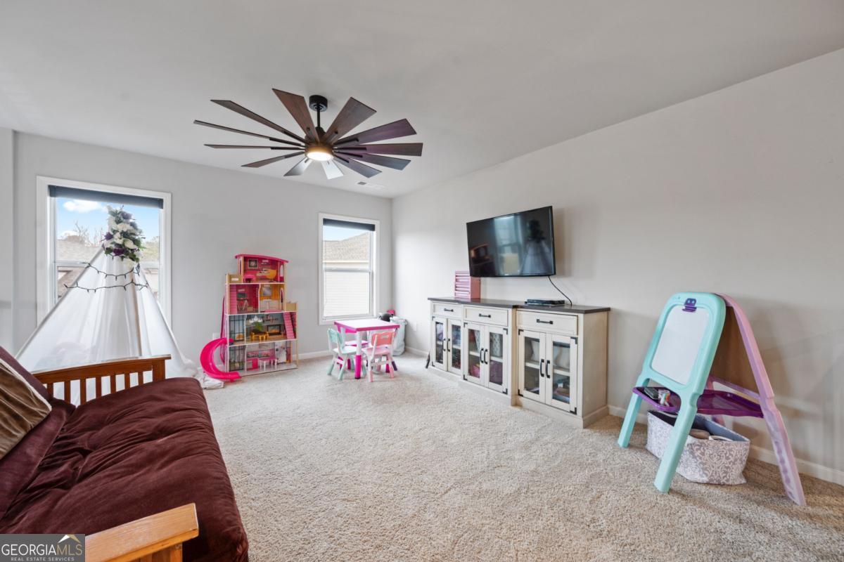 6780 Rambling Vale Dawsonville, GA 30534 - Photo 24 of 52 a living room with furniture a flat screen tv and gym equipment