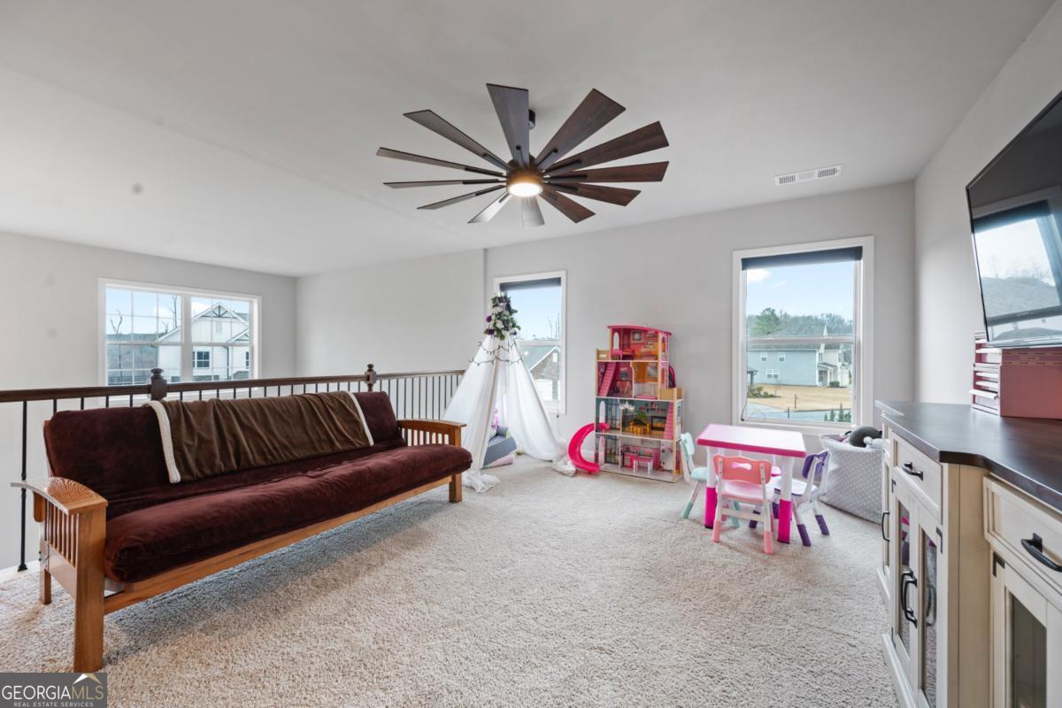 6780 Rambling Vale Dawsonville, GA 30534 - Photo 25 of 52 a living room with furniture a ceiling fan and a window