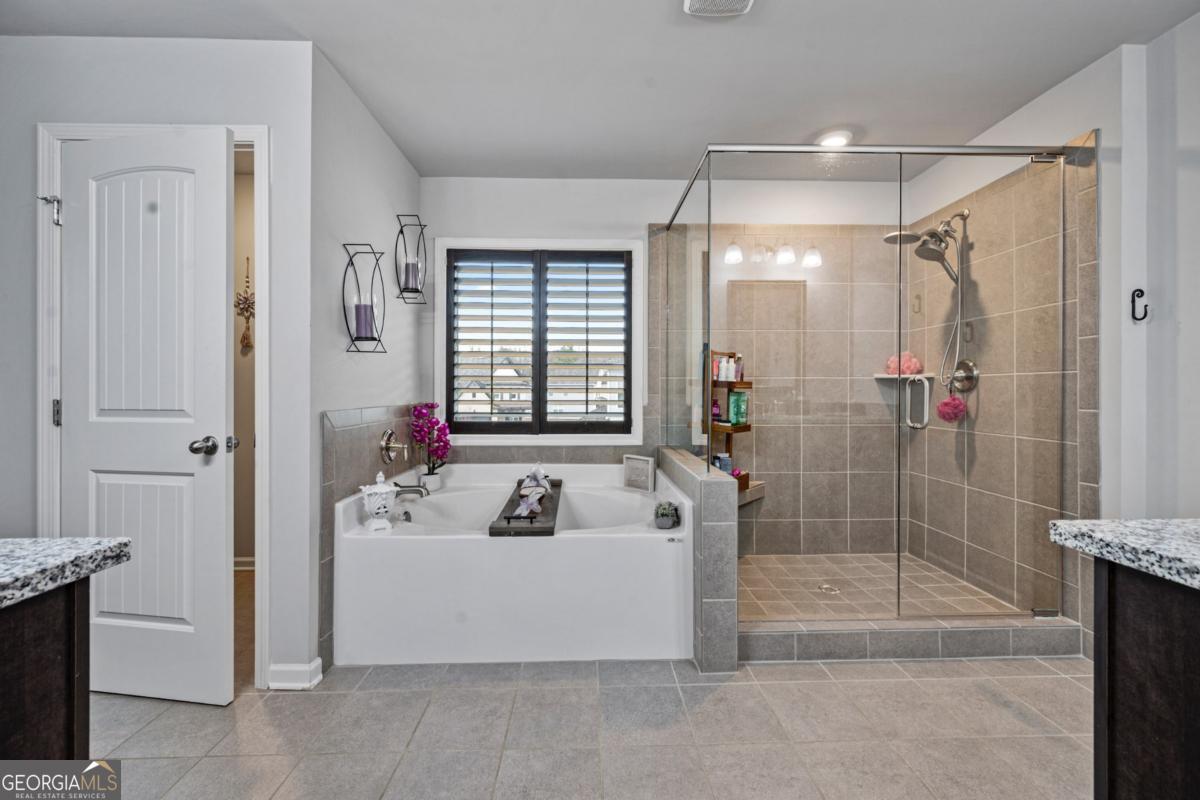 6780 Rambling Vale Dawsonville, GA 30534 - Photo 32 of 52 a bathroom with a tub shower and mirror