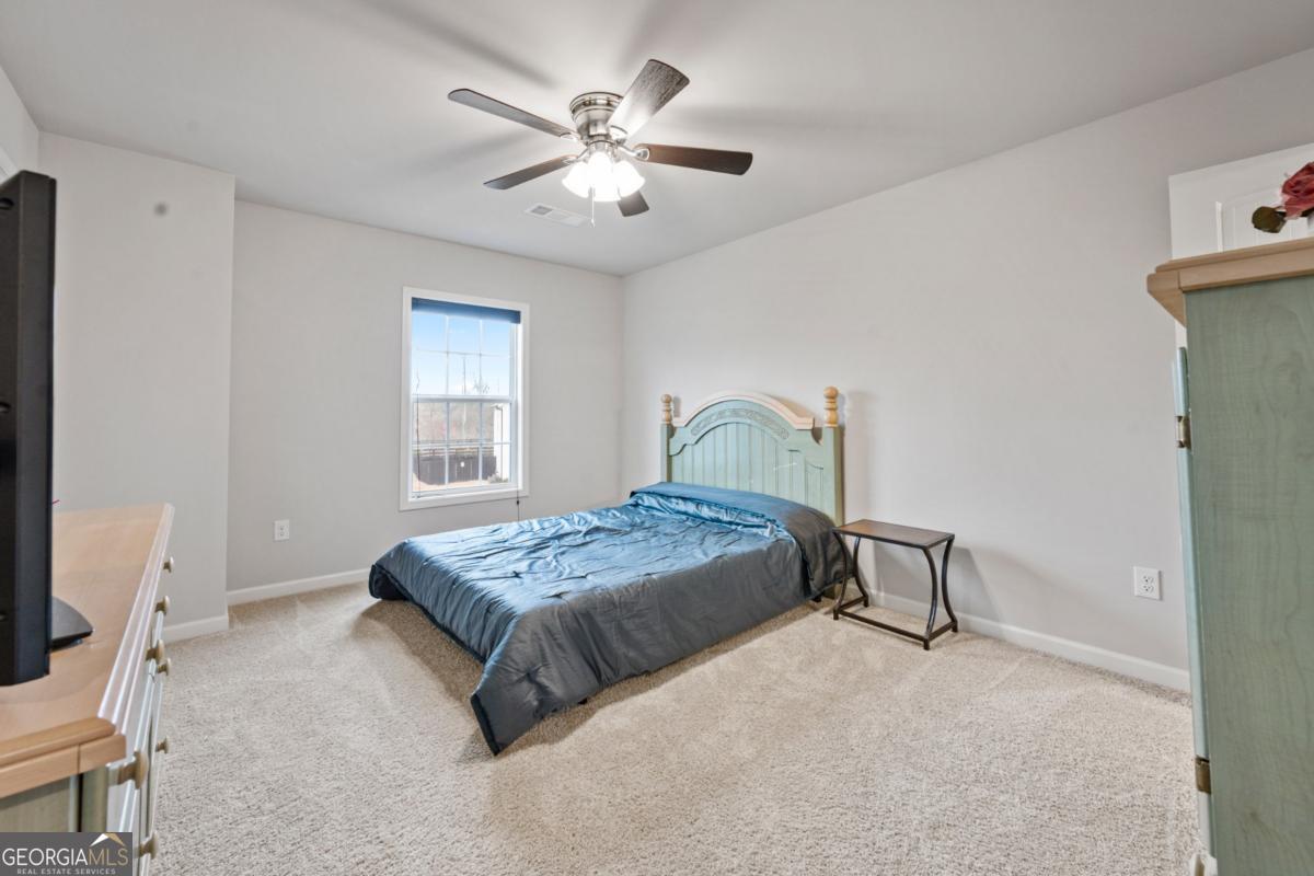 6780 Rambling Vale Dawsonville, GA 30534 - Photo 37 of 52 a bedroom with a bed and a chandelier