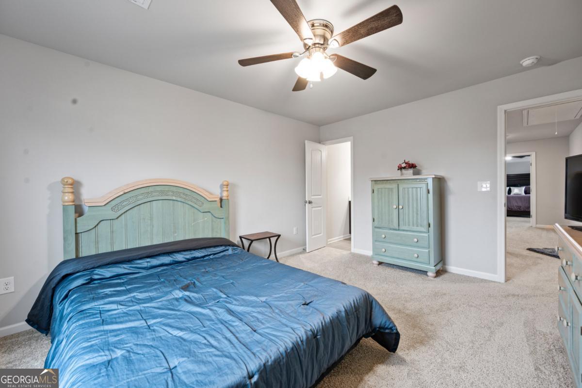 6780 Rambling Vale Dawsonville, GA 30534 - Photo 39 of 52 a bedroom with a bed and a chandelier