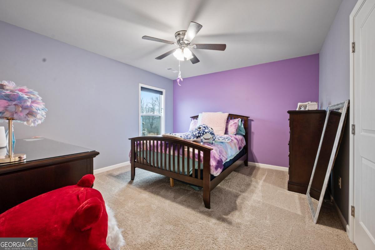 6780 Rambling Vale Dawsonville, GA 30534 - Photo 41 of 52 a bedroom with a bed and a chandelier