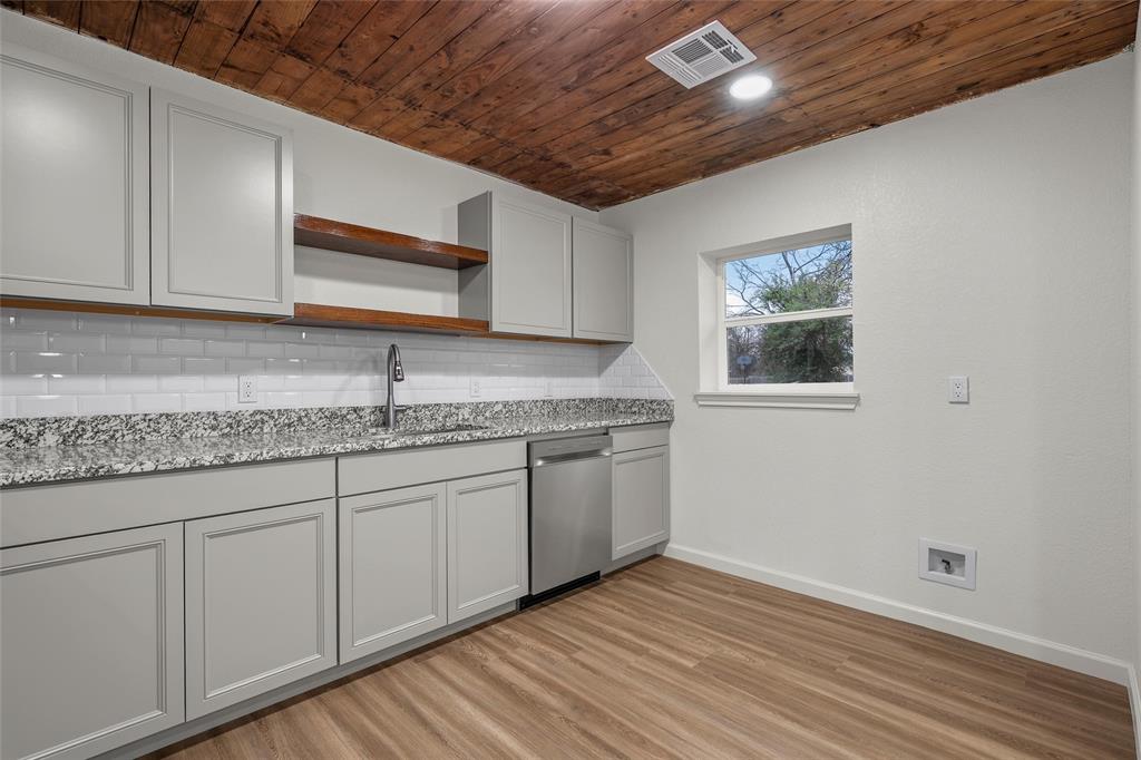 506 Rose Street Waco, TX 76704 - Photo 11 of 25 a kitchen with granite countertop cabinets stainless steel appliances a sink and wooden floor