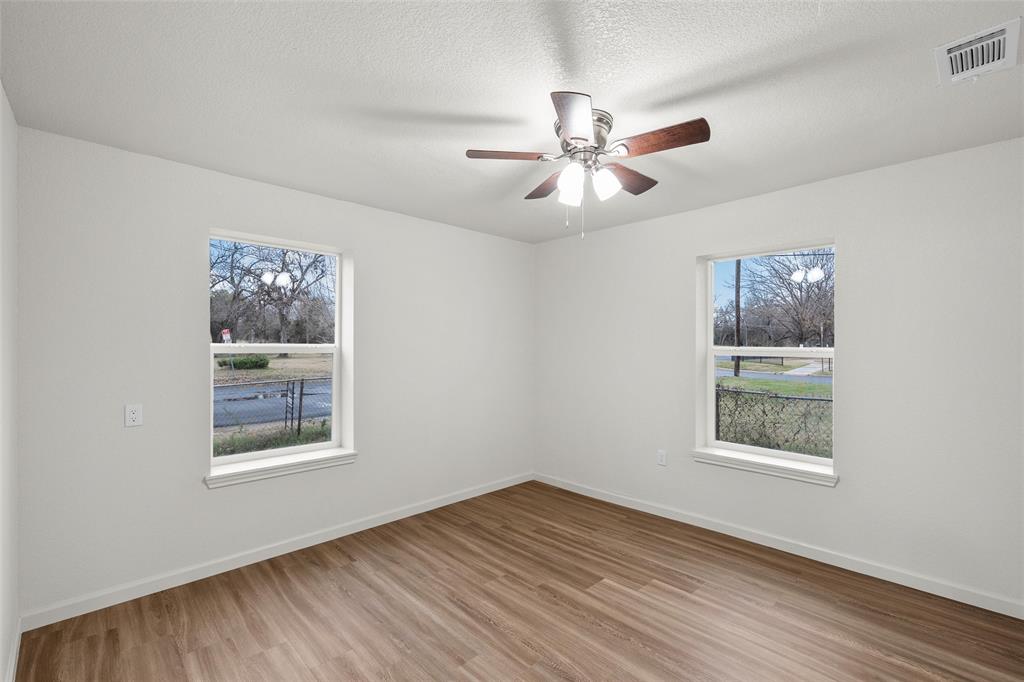 506 Rose Street Waco, TX 76704 - Photo 12 of 25 a view of an empty room with a window and wooden floor