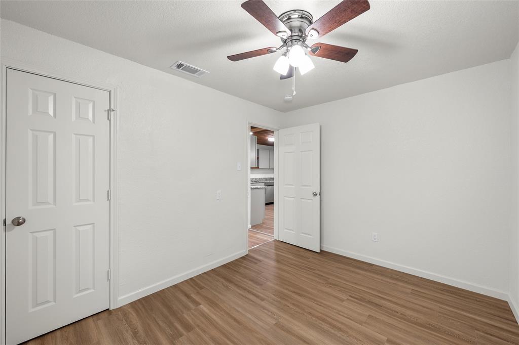506 Rose Street Waco, TX 76704 - Photo 16 of 25 an empty room with wooden floor chandelier fan and closet area