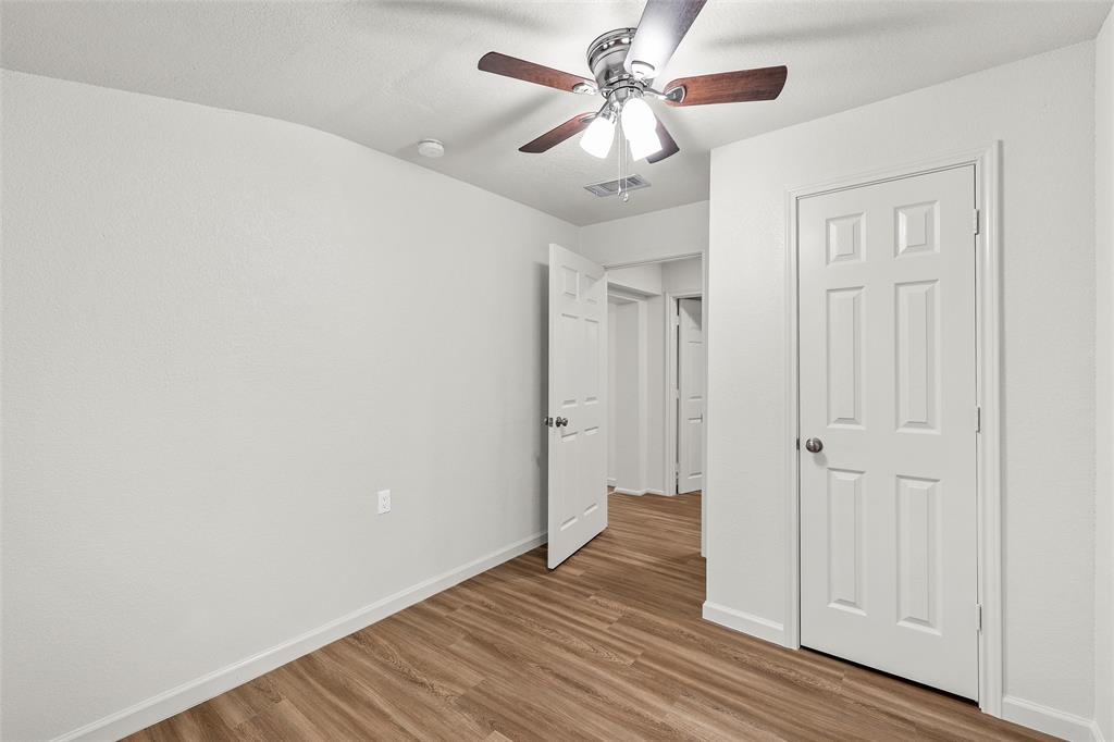506 Rose Street Waco, TX 76704 - Photo 19 of 25 an empty room with wooden floor fan and windows