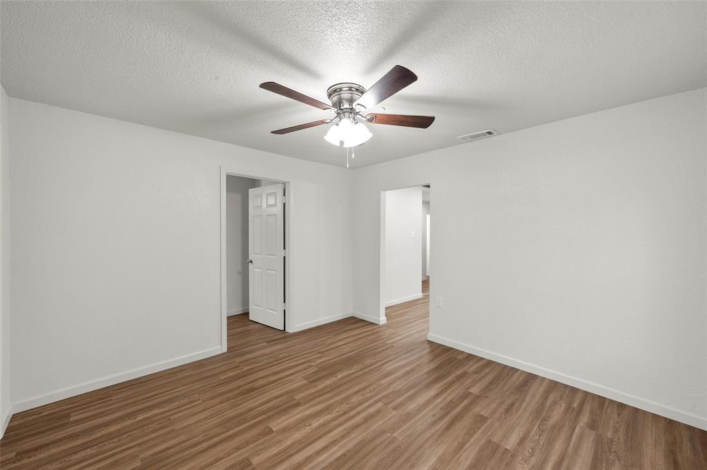 506 Rose Street Waco, TX 76704 - Photo 4 of 25 a view of a big room with wooden floor and a ceiling fan