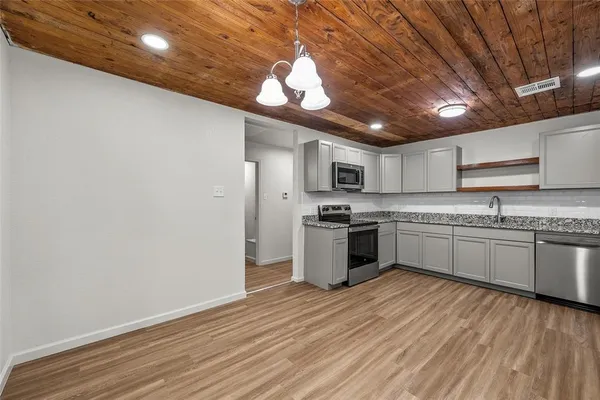 a large kitchen with kitchen island a sink stainless steel appliances and cabinets