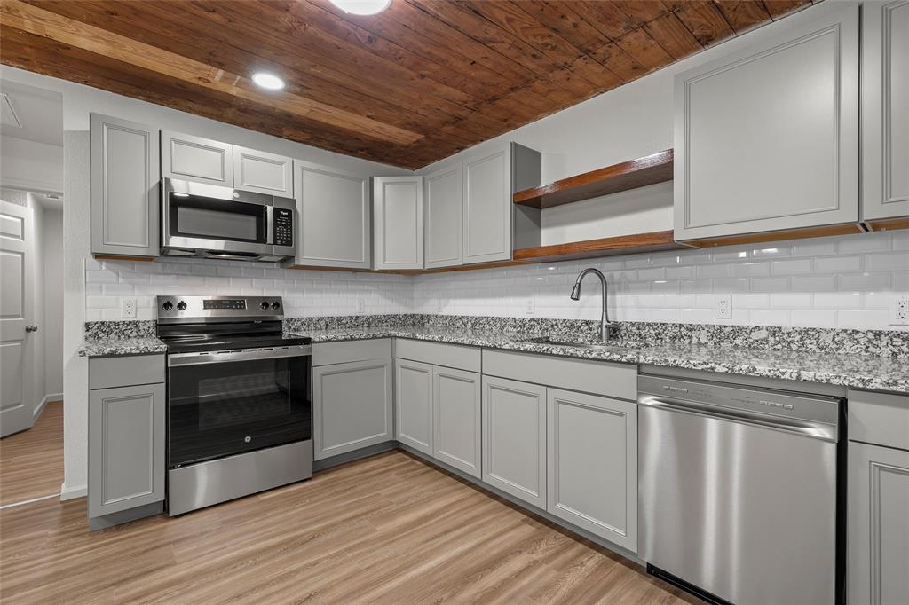 506 Rose Street Waco, TX 76704 - Photo 9 of 25 a kitchen with granite countertop wood cabinets stainless steel appliances and a sink