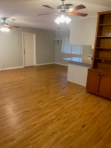 an empty room with kitchen and view of bathroom