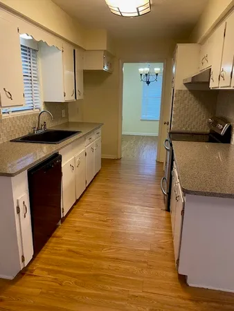 a kitchen with stainless steel appliances granite countertop a sink and wooden cabinets