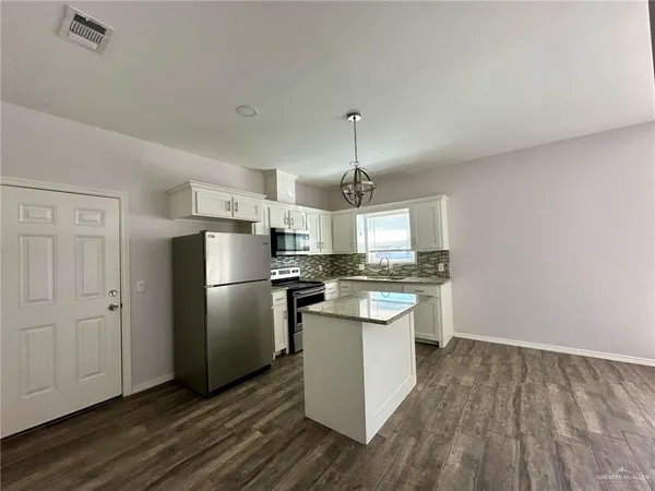 a kitchen with stainless steel appliances a refrigerator and wooden floor