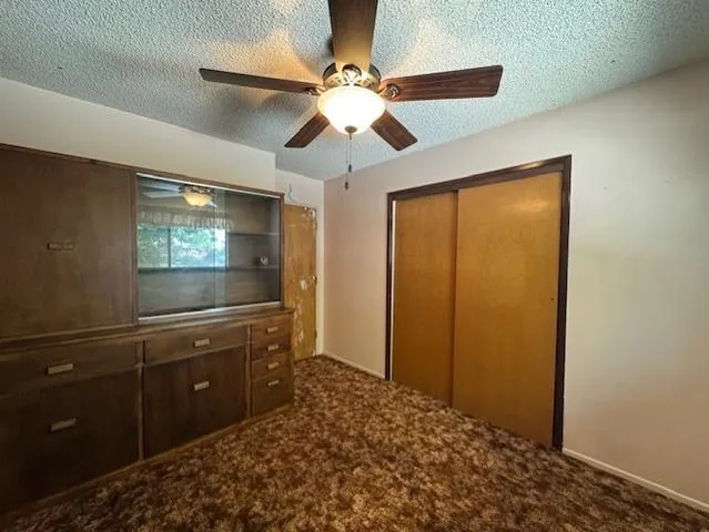 an empty room with a fan and a fan