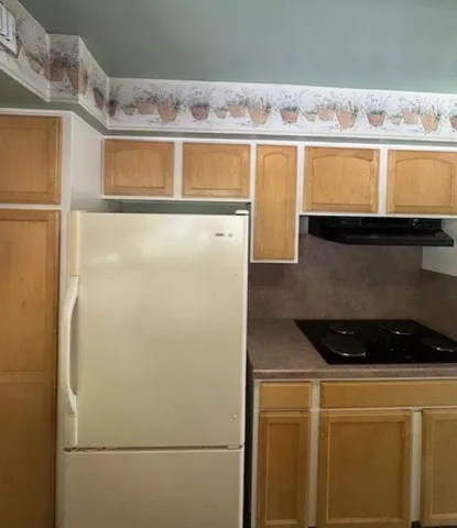 a view of a kitchen with stainless steel appliances granite countertop a refrigerator and a stove