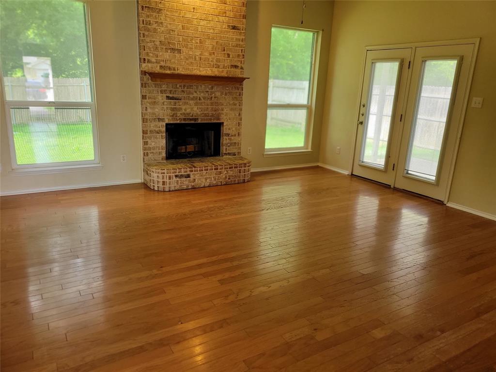 1764 Independence Road Blue Mound, TX 76131 - Photo 2 of 13 an empty room with wooden floor fireplace and windows