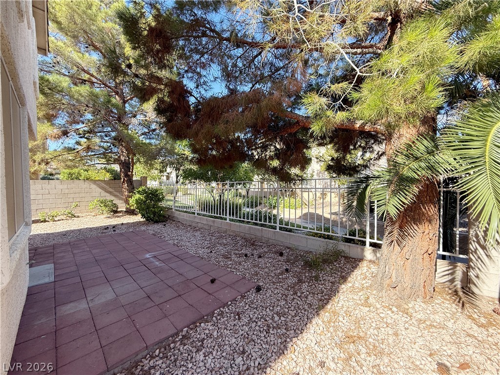 2185 Polynesia Circle Henderson, NV 89074 - Photo 36 of 37 A tranquil outdoor retreat with a paved patio and lush surrounding trees.