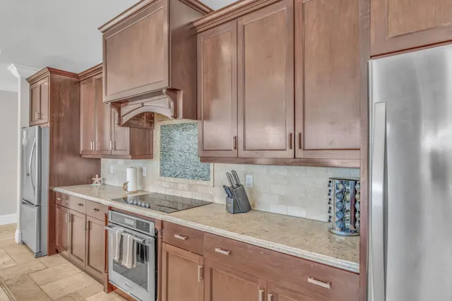 a living room with furniture kitchen view and a chandelier