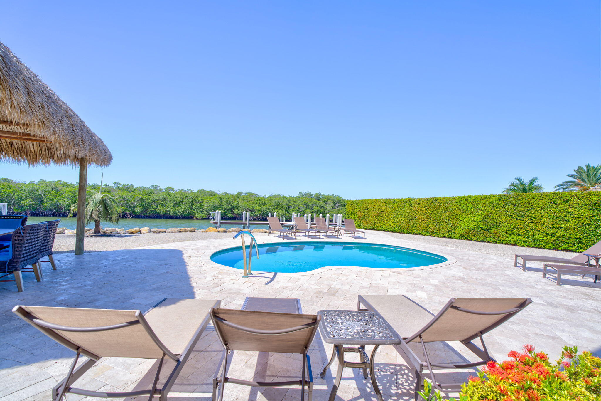 2394 Coco Plum Drive Marathon, FL 33050 - Photo 48 of 56 a view of a swimming pool with lawn chairs under an umbrella