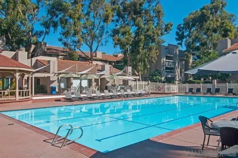 a view of a swimming pool with chairs and tables