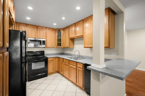 a kitchen with stainless steel appliances granite countertop a refrigerator a sink and a stove