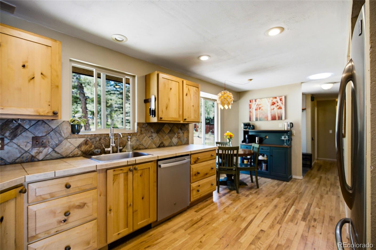 31280 Florence Road Conifer, CO 80433 - Photo 14 of 48 a kitchen with stainless steel appliances granite countertop a sink cabinets and wooden floor