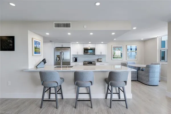 a large white kitchen with a table and chairs in it