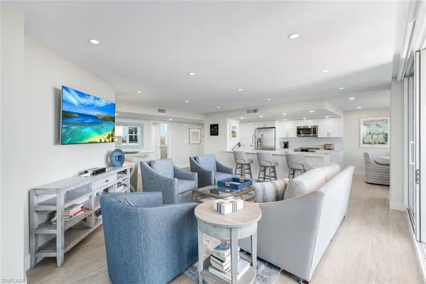 a living room with furniture a table and kitchen view
